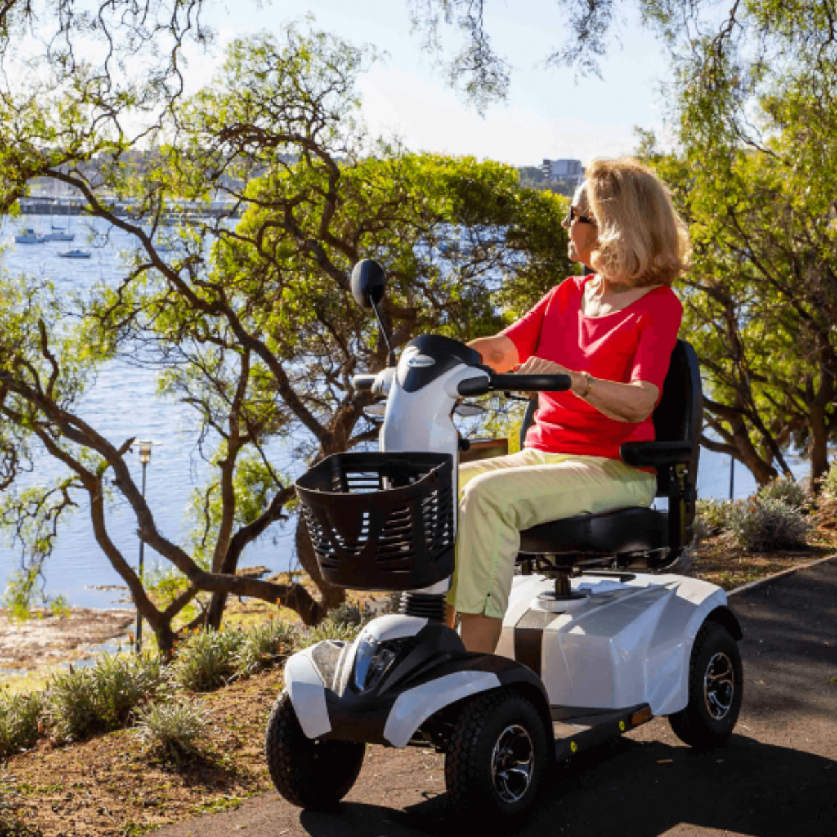 A woman is riding Aspire Midi Deluxe HS520 Four-Wheel Mobility Scooter