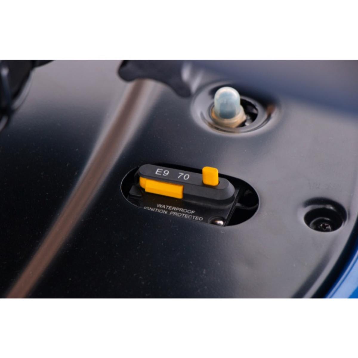 Close-up of a vehicle's fuel cap with E9 70 label on a black background