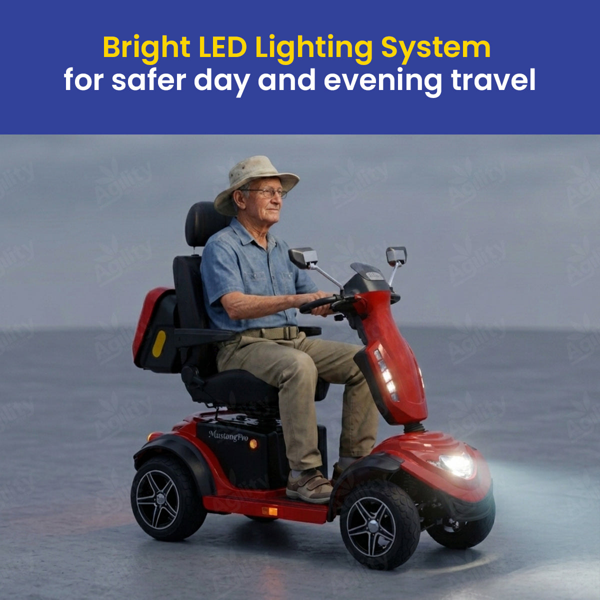 Man riding a red Mustang Pro Heavy Duty Mobility Scooter with bright LED lighting system on a gray background