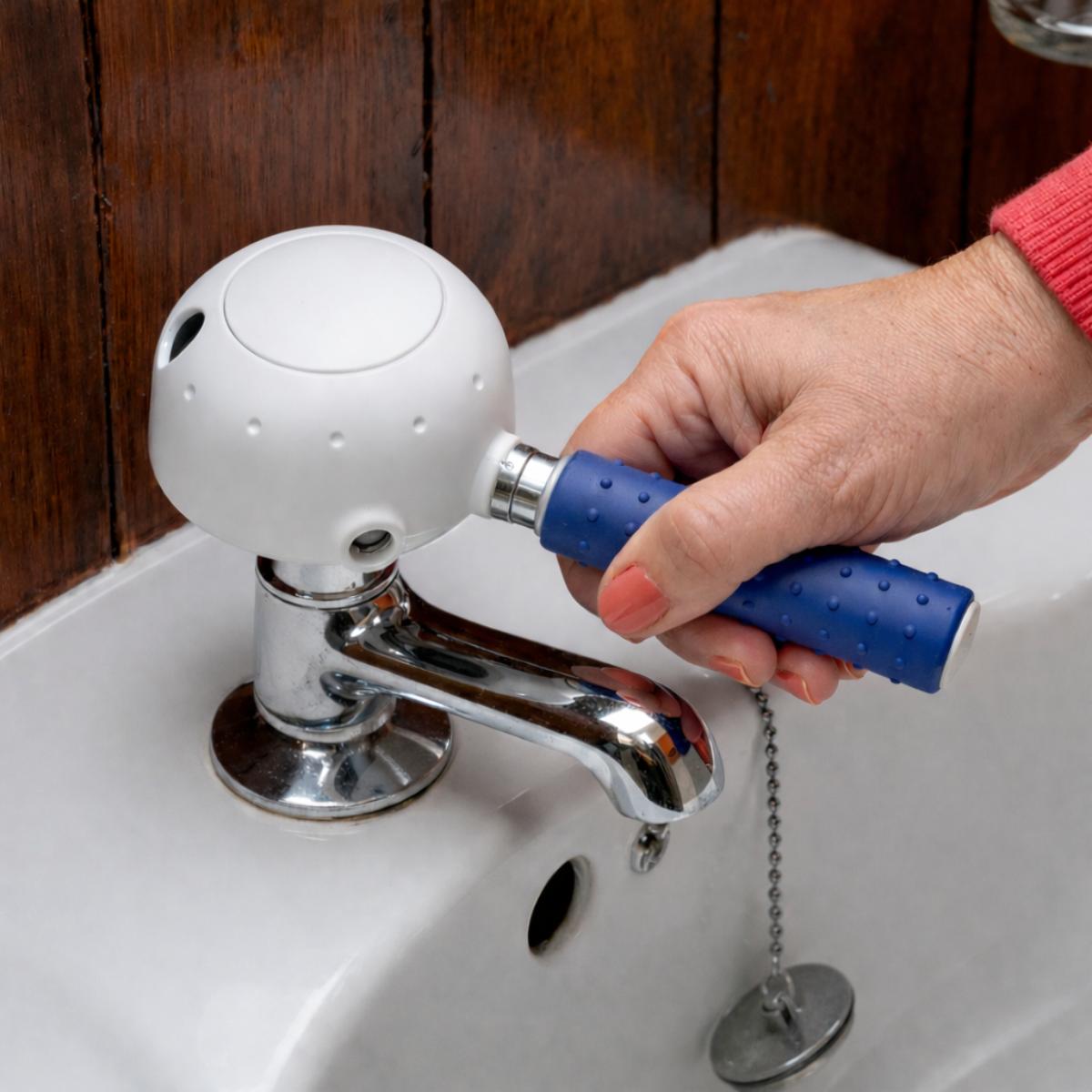 Person using a tap turner on a sink with a wooden wall background